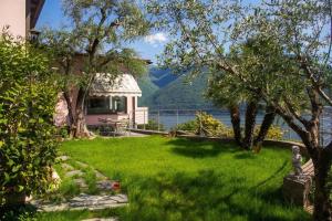 a house with a lawn with a view of the water at Il Tentione in Valsolda +37 photos