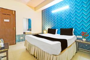 a bedroom with a large bed with a blue wall at Hotel O Honey Inn in New Delhi +21 photos