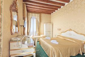 a bedroom with two beds and a mirror at Locanda Correr in Venice