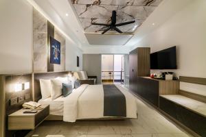 a bedroom with a large bed with a ceiling at Samann Blue in Hulhumale