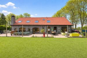 a house with a red roof and a yard at Landgoed Rotermundt in Huijbergen