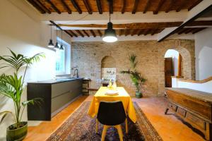 a kitchen with a table with a yellow table cloth at Il Nido dell'Oca - Loft Giardino in Siena +27 photos