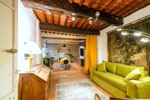a living room with a green couch and a table at Il Nido dell'Oca - Loft Giardino in Siena