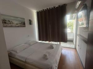 a bed in a room with a large window at Old Town Apart in Budva +5 photos