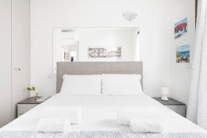 a white bedroom with a large white bed at EASYLIFE - Como - Crotta 3 - Argegno in Argegno +45 photos