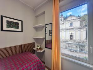 a bedroom with a window with a view of a building at vitalArmonie Retreat in Marzio +97 photos