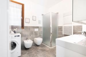a bathroom with a toilet sink and a washing machine at EASYLIFE - Como - Crotta 3 - Argegno in Argegno