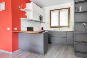 a kitchen with red and white walls and a counter at EASYLIFE - Como - Crotta 3 - Argegno in Argegno