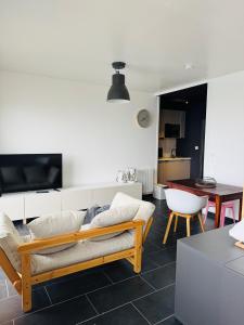 a living room with a couch and a table at Brõcean - Studio with sea view - in Loctudy