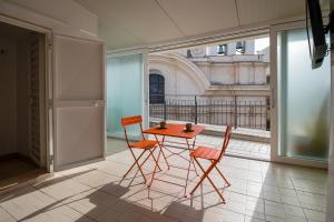a table and chairs in a room with a window at Boemondo 33 in Bari