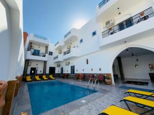 a pool in the middle of a building with yellow chairs at Azure Guest House in Luxor