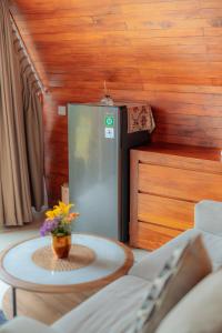 a kitchen with a refrigerator and a table with a vase of flowers at Svargan Lakeside Glamping in Tabanan