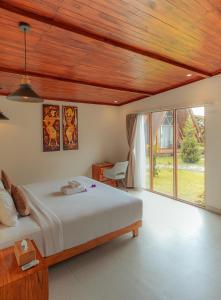 a bedroom with a bed and a large window at Svargan Lakeside Glamping in Tabanan