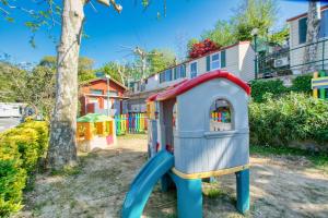 a small playground with a slide in front of a tree at Camping Miraflores in Rapallo