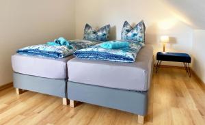 a blue couch with pillows on it in a room at Wiesenhaus, Ferienhaus in Manderscheid