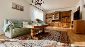 a living room with a green couch and a table at Wiesenhaus, Ferienhaus in Manderscheid