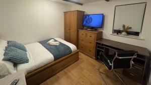 a bedroom with a bed and a flat screen tv at Hidden Gem in Foots Cray