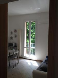 sala de estar con mesa y ventana en Corner Apartment en Bolonia
