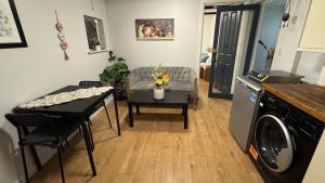 a living room with a couch and a table at Hidden Gem in Foots Cray