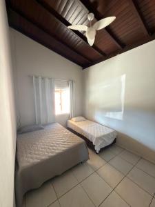 a bedroom with two beds and a ceiling fan at Rancho Renato Chaveiro in Capitólio +20 photos