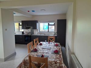 a dining room with a table and a kitchen at Tigh Fitz Apartments - Inis Mór, Aran Island in Inis Mor +25 photos