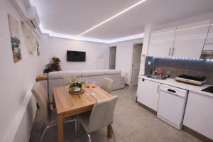 a kitchen and dining room with a wooden table in a room at VIP private Poolsuite Calafell in Calafell