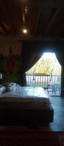 a bedroom with a bed with a view of a porch at Rivana Inn - ريفانا in ‘Izbat an Nāmūs