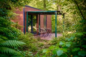 a cabin in the woods with a table and chairs on a deck at Hotel Les Lodges de Vaugrigneuse in Vaugrigneuse +21 photos