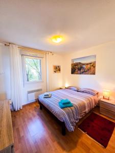 a bedroom with a bed and a window at Chez Jiri - Piscine, Balcon vue Alpes, Spacieux T2 in Gex +20 photos