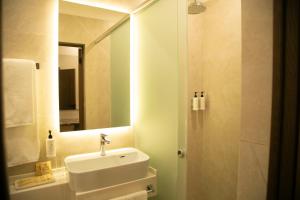 a bathroom with a sink and a shower with a mirror at Aristocrat Hotel in Kapchagay