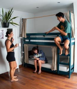 a man and a woman standing next to a bunk bed at Tamaran House in Las Palmas de Gran Canaria