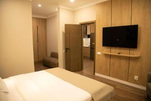 a hotel room with a bed and a flat screen tv at Aristocrat Hotel in Kapchagay