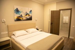 a bedroom with a bed and a painting on the wall at Aristocrat Hotel in Kapchagay +46 photos