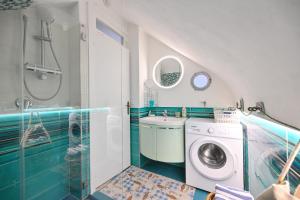 a bathroom with a washing machine and a sink at Beach House Ischia - Seafront & Aragonese Castle View - in Ischia Town