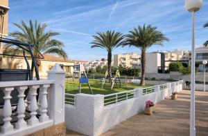 a white fence with palm trees in the background at Casa Claudia&Simon in Santa Pola