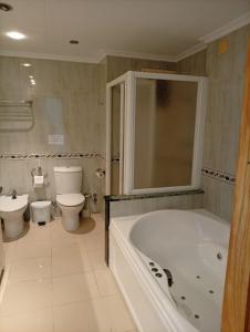 a bathroom with a tub and a toilet and a sink at Hotel Iberflat Marynton in Benicarló
