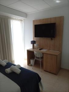 a bedroom with a bed and a desk with a television at Hotel Iberflat Marynton in Benicarló +24 photos