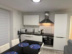 a kitchen with a table with chairs and a stove at Un bon momentde dente in Bonneville +58 photos