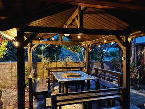a wooden gazebo with a table and benches at Biwako Villa 縁 in Takashima