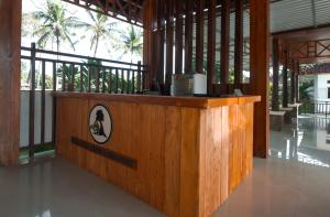 a wooden counter in a building with palm trees at Pohon Purba Resort & Restaurant in Pulau Lebur