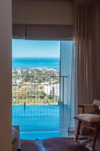 a room with a large window with a view of the ocean at Whale Coast Luxury Suites in Hermanus