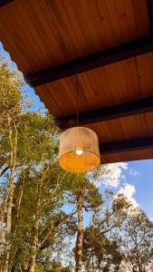 a light hanging from a wooden ceiling with trees at Pousada Refúgio Arauca in Campo Alegre