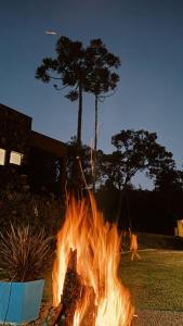 a fire burns in a yard with trees in the background at Pousada Refúgio Arauca in Campo Alegre