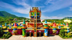a colorful building in a park with mountains in the background at Pousada Luz do Sol in Penha
