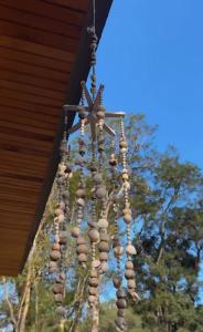 a chandelier made of wooden beads hanging from a roof at Pousada Refúgio Arauca in Campo Alegre