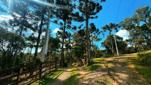 a dirt road next to a fence and trees at Pousada Refúgio Arauca in Campo Alegre +42 photos