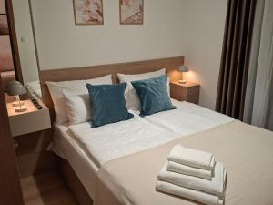 a bedroom with a large bed with blue pillows at Silver Marina Residence in Veliko Gradište