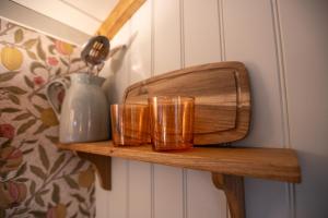 a shelf with two glasses and a vase on it at The Carriage in Kenton +2 photos