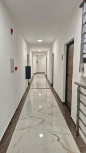 a corridor in a building with marble floors and white walls at Silver Marina Residence in Veliko Gradište