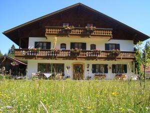 a house with flowers on the balconies in a field at Zoberhof - Ferienhof zum Zoberbauer in Oberammergau